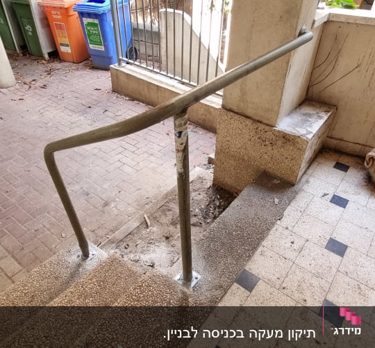 מעקה מתכת על מדרגות בכניסה לבניין